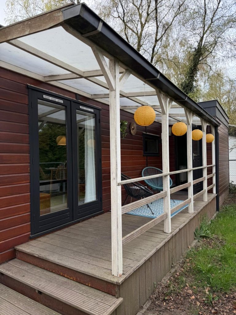 Houten terras met lampions aan het huisje