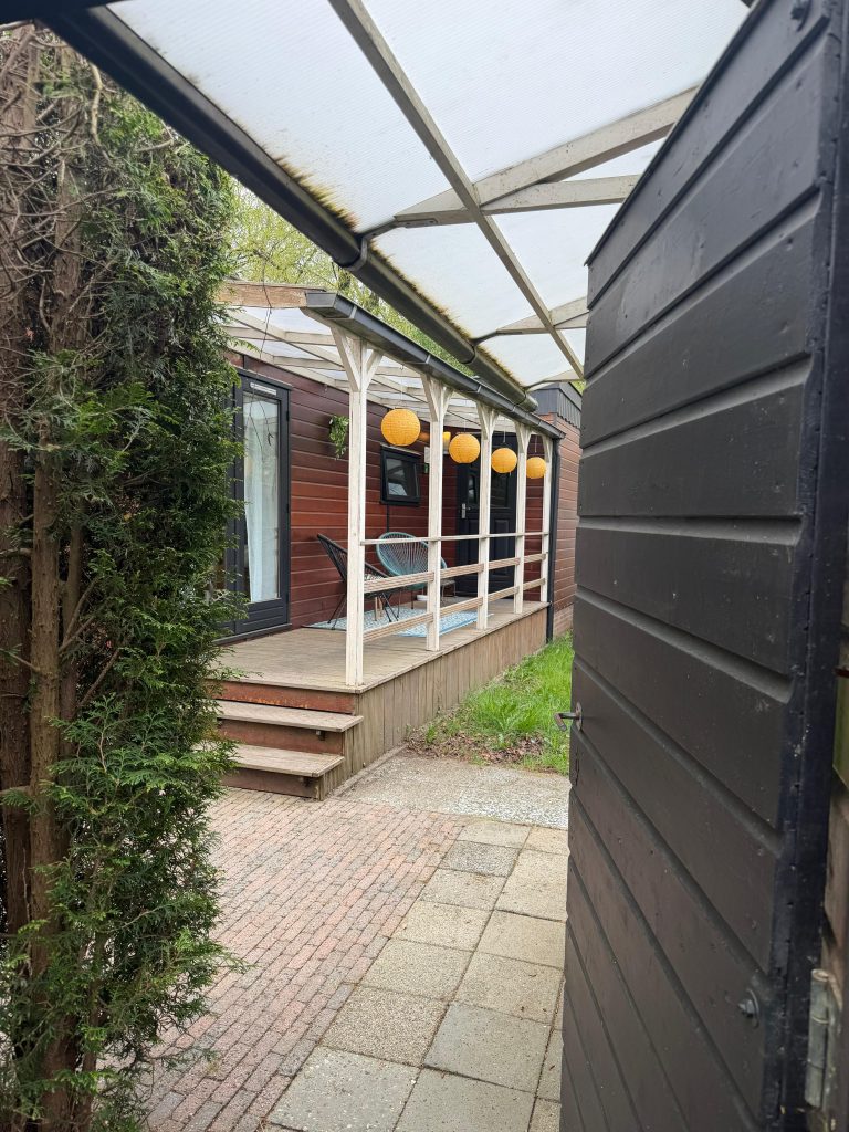 Zijpad langs het huisje met zicht op de veranda